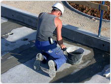 Ouvrier travaillant du ciment à genoux